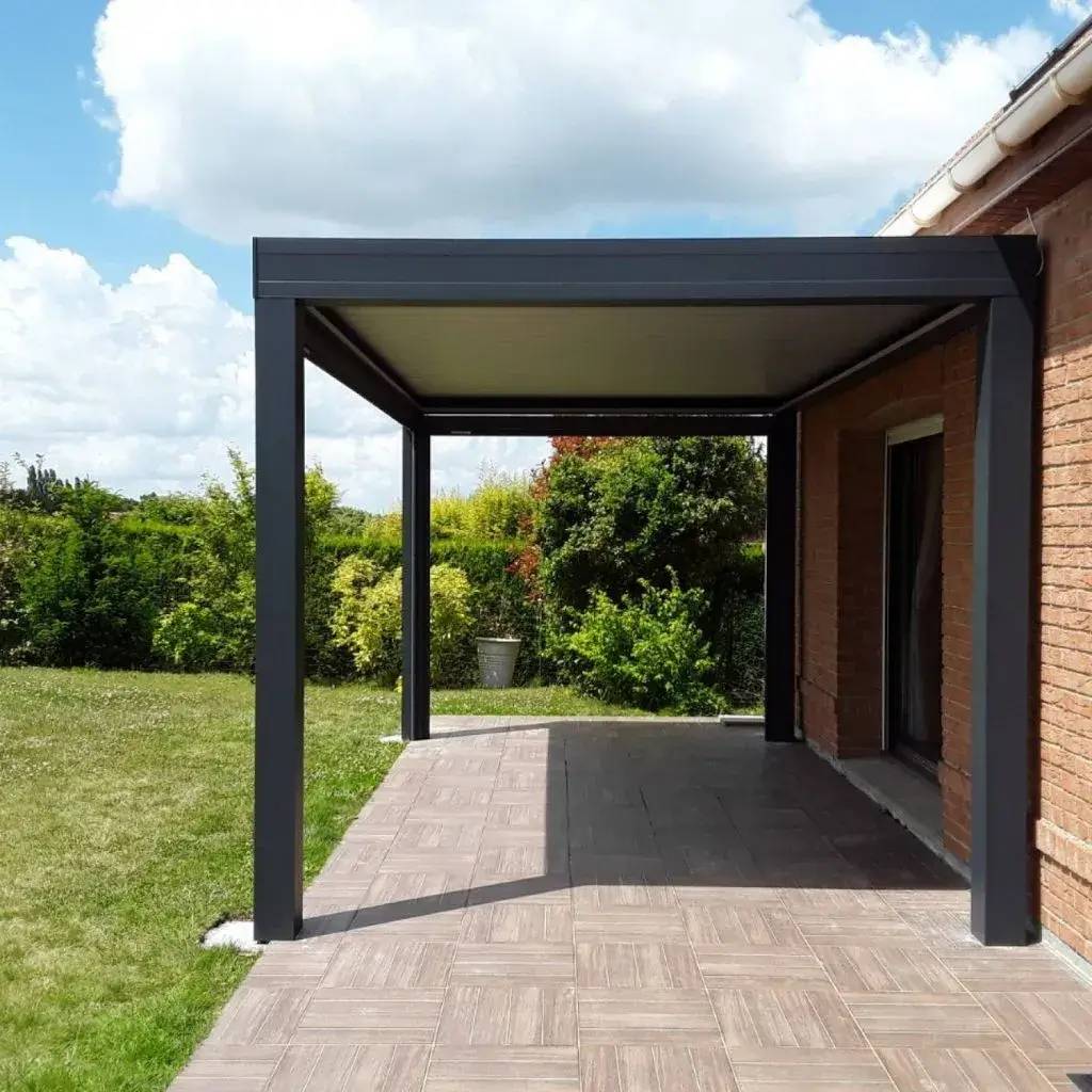 Une terrasse moderne avec un auvent minimaliste en métal noir, entourée d'un jardin verdoyant.