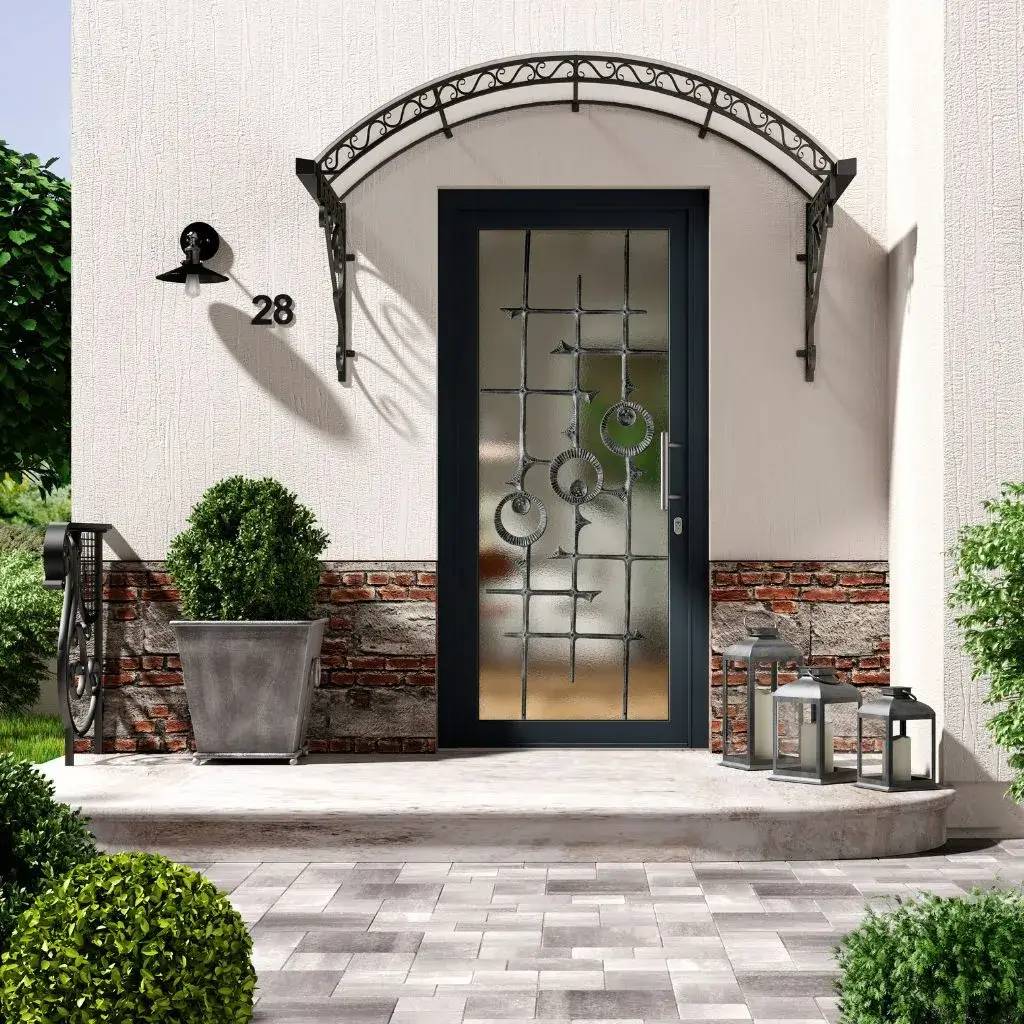 La photo montre une porte d'entrée moderne avec une vitre décorative et un auvent en fer forgé, entourée de lanternes et de végét