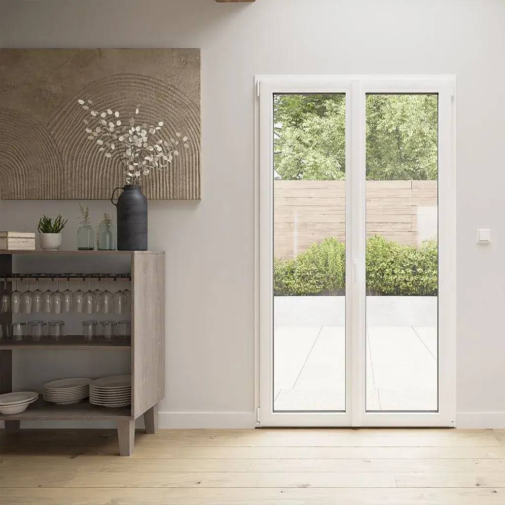 Une pièce lumineuse avec une porte-fenêtre en verre donnant sur un jardin verdoyant, accompagnée d'un bahut en bois décoré d