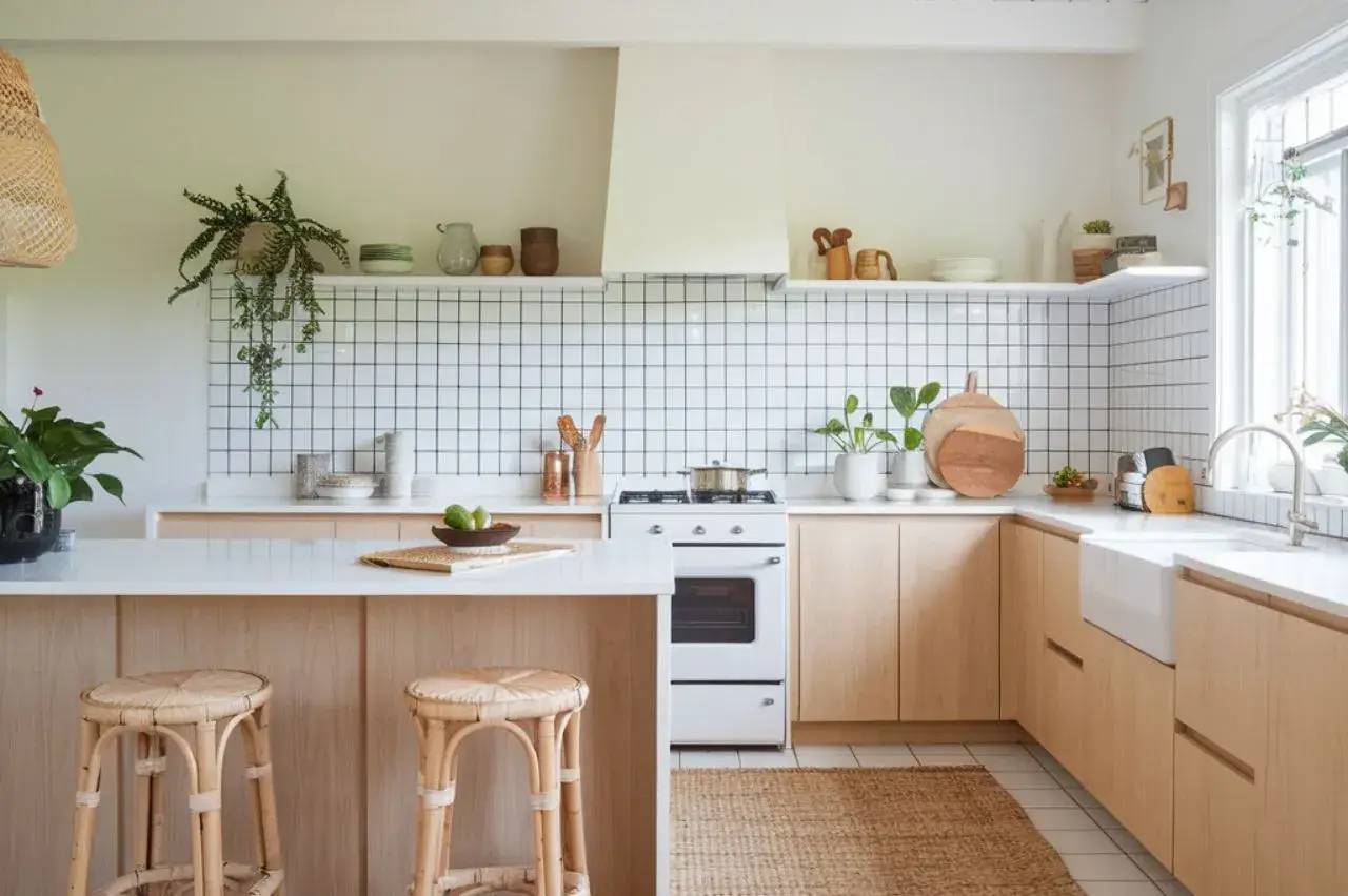 Cuisine moderne et lumineuse avec un design minimaliste incluant des éléments en bois clair et des plantes vertes décoratives.
