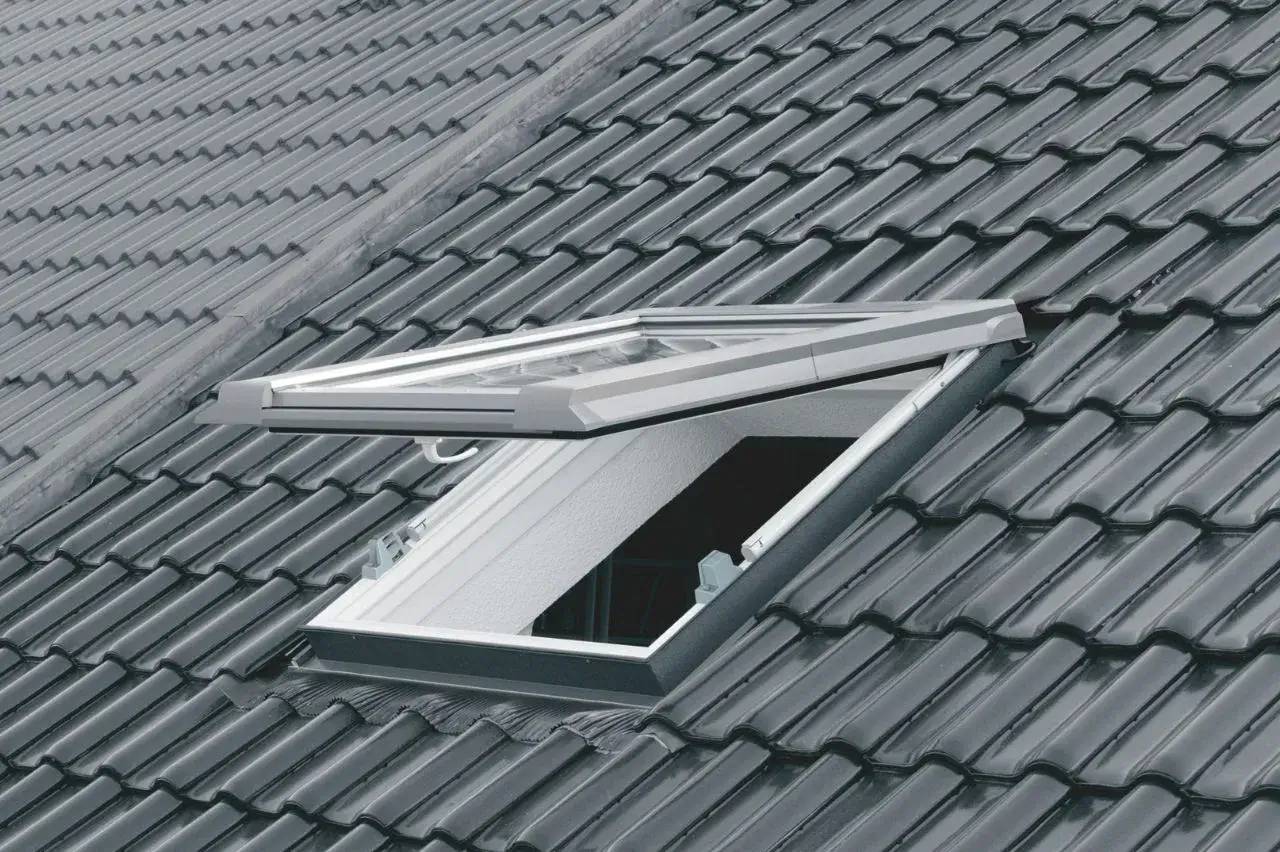 Fenêtre de toit moderne ouverte intégrée dans un toit en tuiles grises.