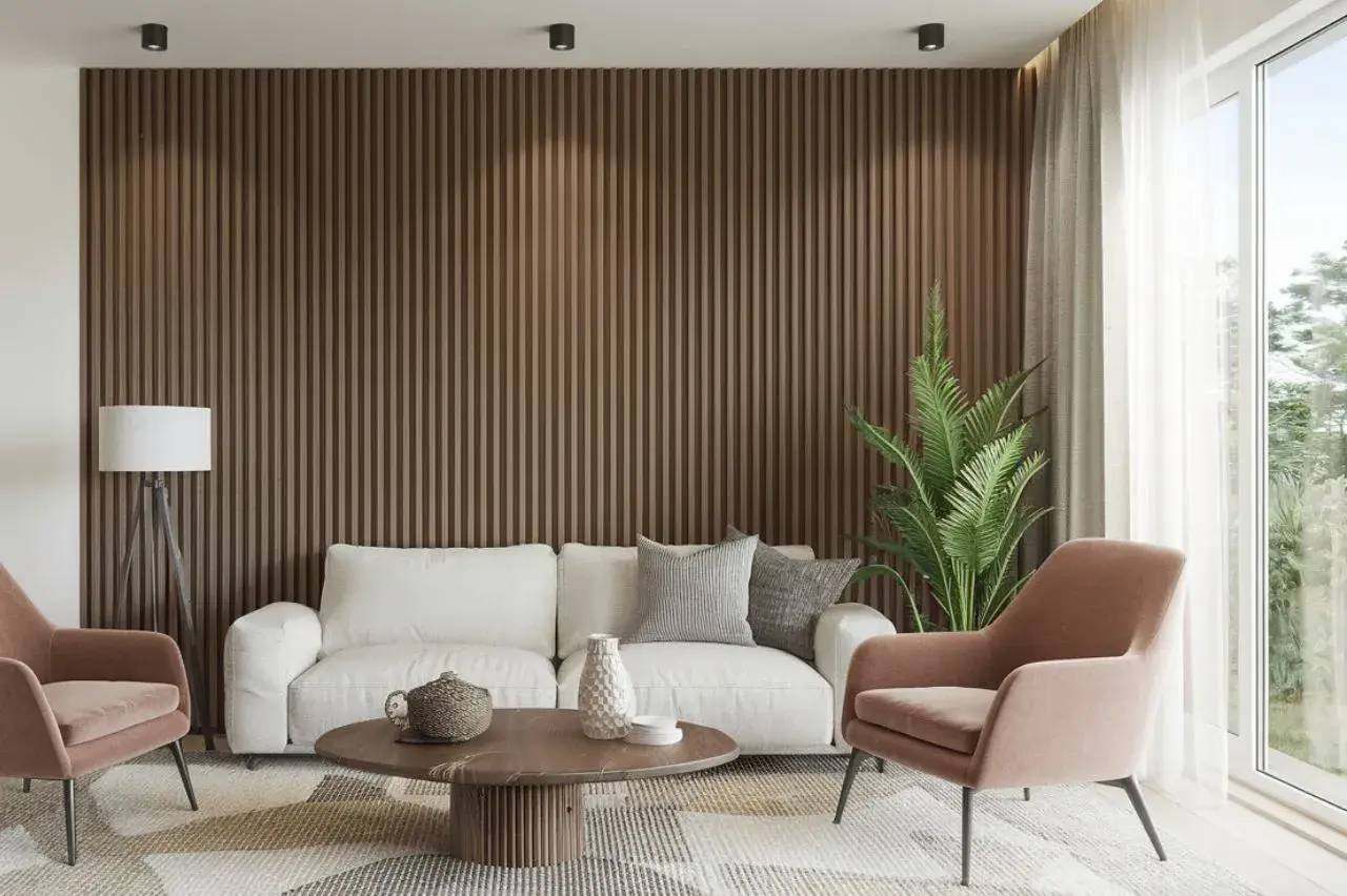 Un salon moderne avec un canapé blanc, des fauteuils roses, une table basse en bois, une grande plante verte et un mur texturé brun.