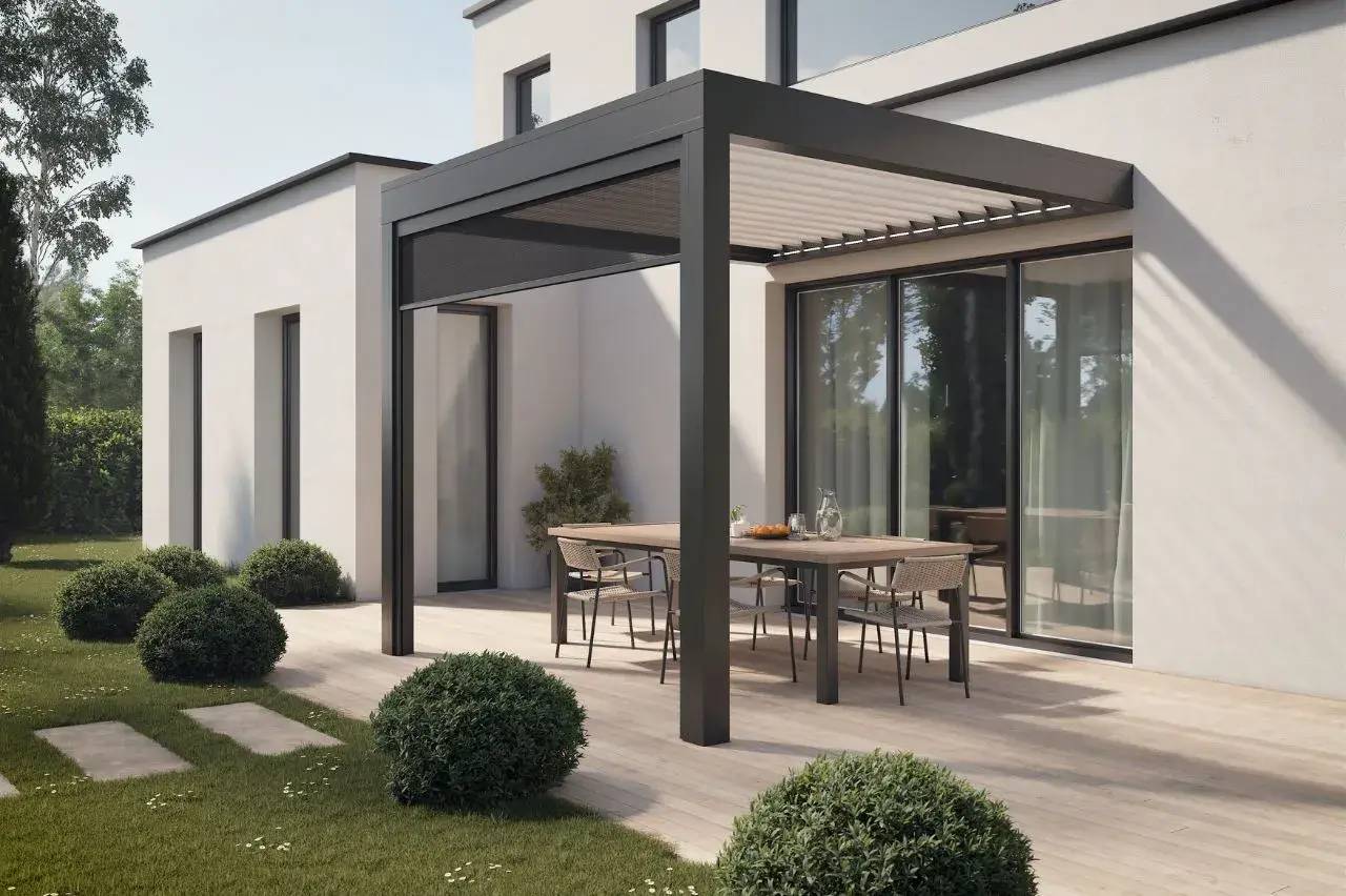 Terrasse moderne avec pergola en aluminium, table en bois et fauteuils tressés, entourée de verdure.