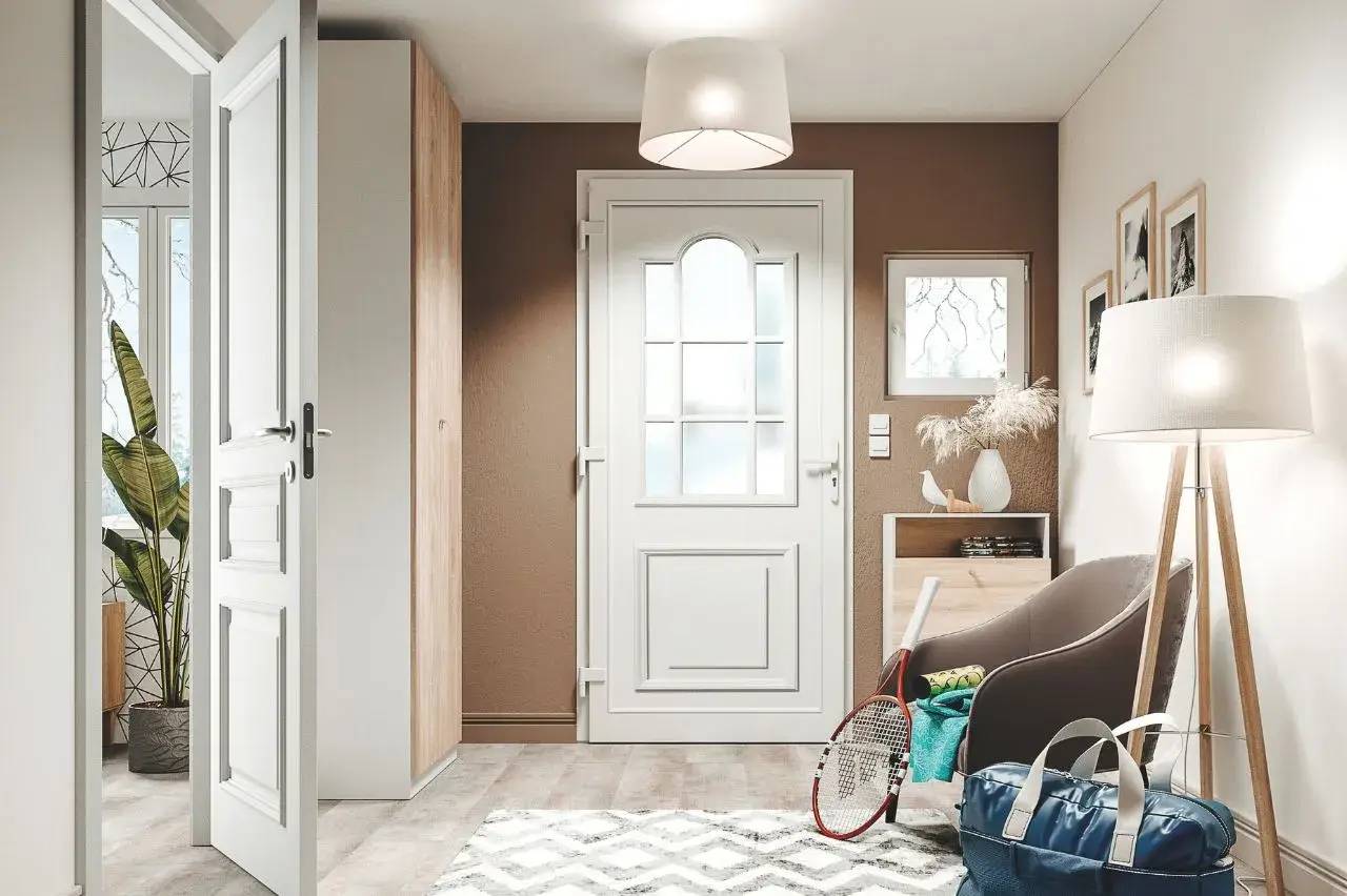 Un hall d'entrée moderne avec une porte blanche, des murs marron et crème, un meuble et fauteuil combinés, décoré de cadres, plantes