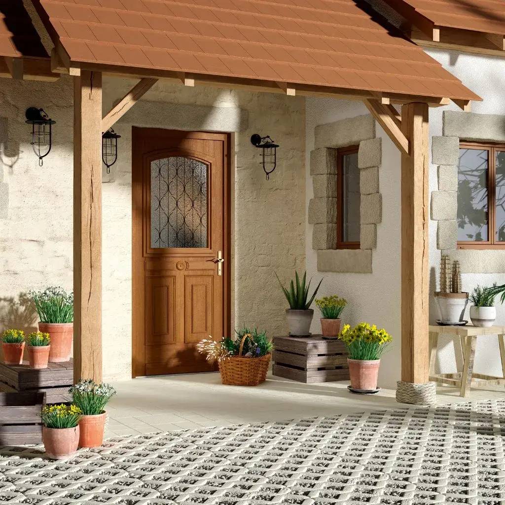Entrée d'une maison en pierre avec porte en bois, abri en briques rouges, et plantes en pot.