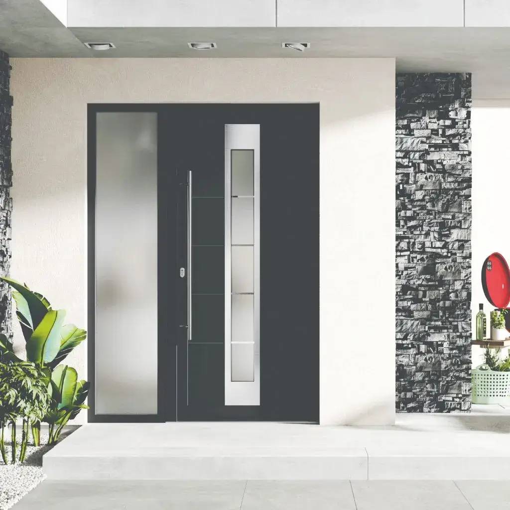 Entrée moderne avec porte en verre et aluminium encadrée de pierres grises, accompagnée de plantes décoratives.