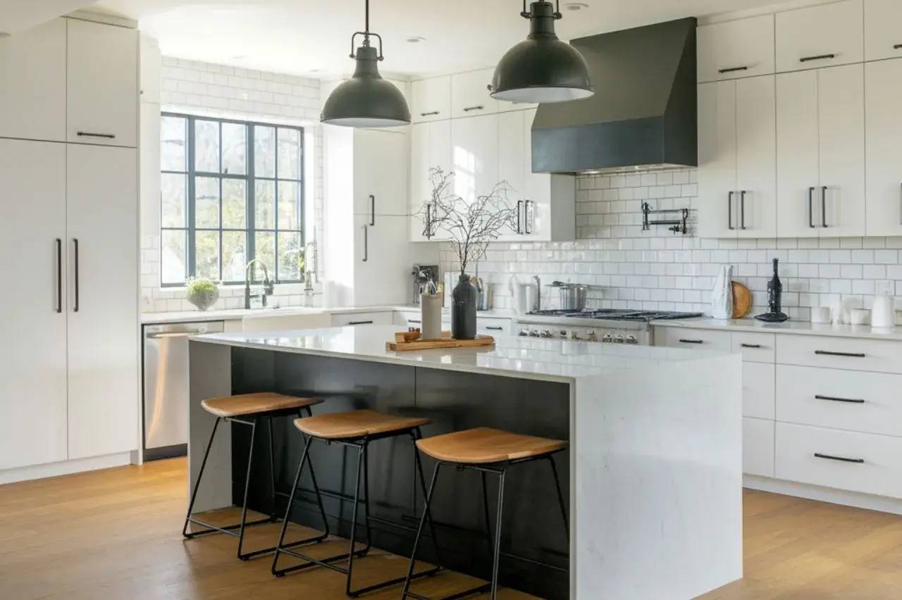Cuisine moderne avec un îlot central en marbre, tabourets en bois, et luminaires suspendus.