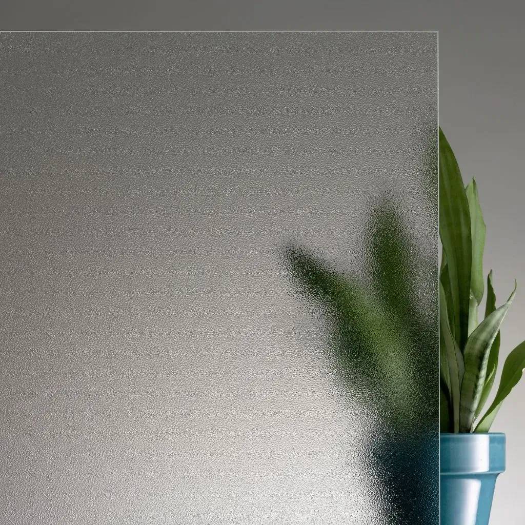 Panneau de verre dépoli laissant entrevoir un pot de plante vert en arrière-plan.