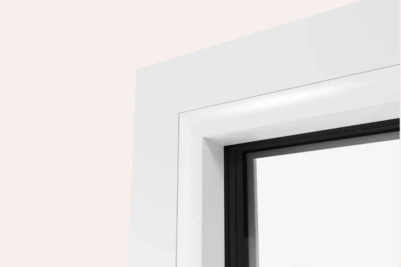 Gros plan sur le coin supérieur d'une fenêtre moderne avec un cadre blanc et des bords sombres.