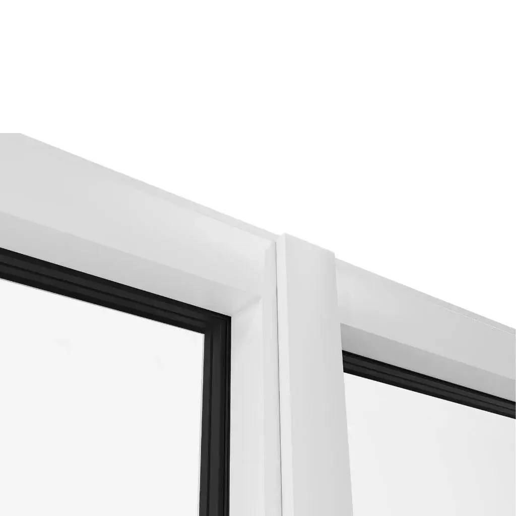 Gros plan sur le coin supérieur d'une fenêtre moderne avec un encadrement blanc et des joints noirs.