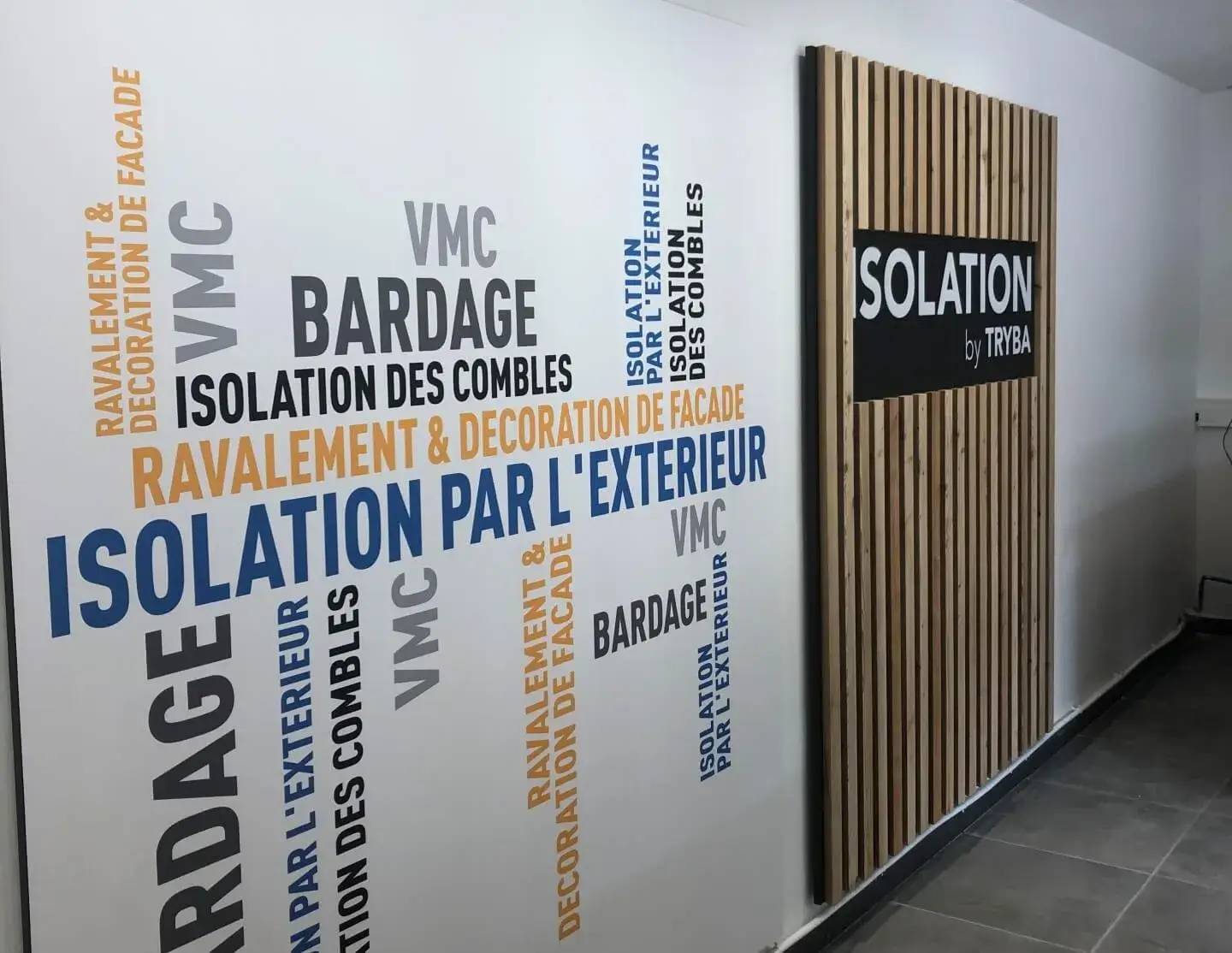 Une image montrant un mur avec des mots-clés sur l'isolation et le bardage entourant une partie en bois portant le logo "Isolation